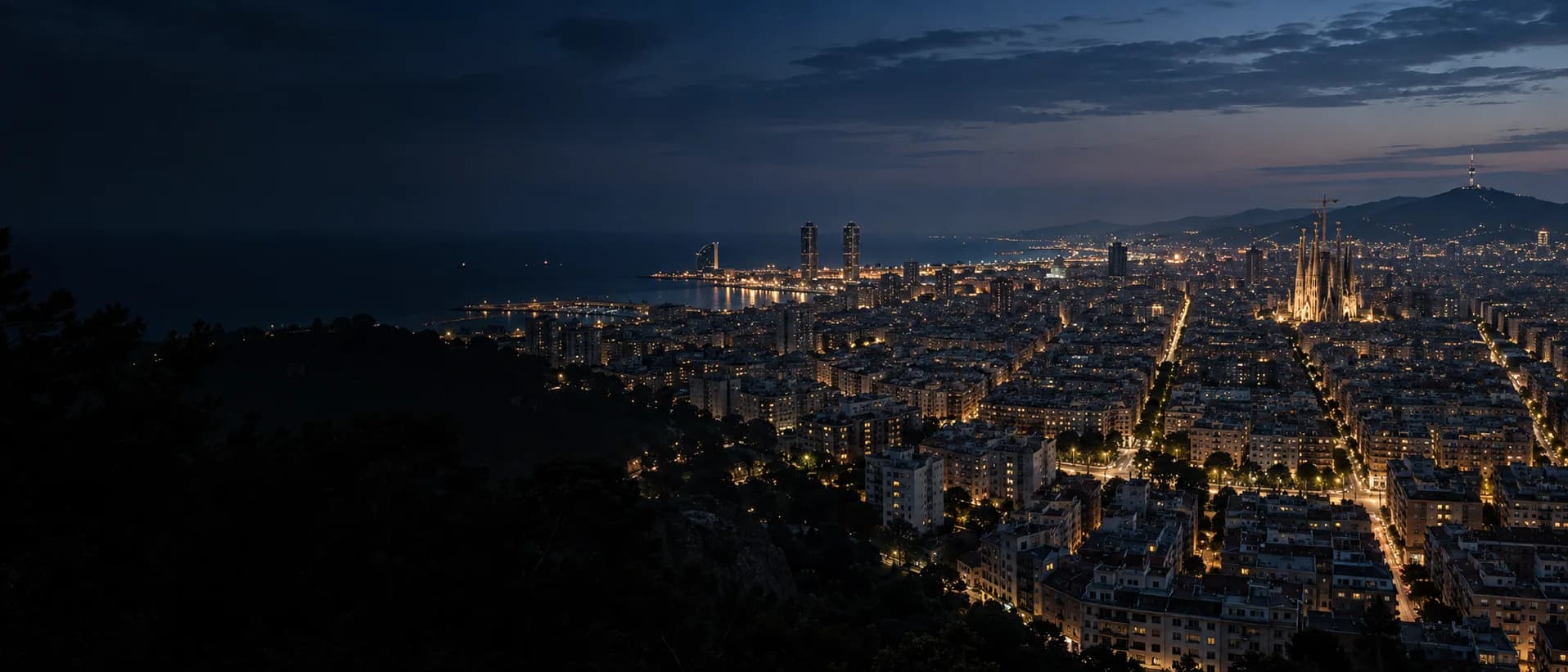 Vista nocturna panorámica de Barcelona con el perfil urbano iluminado